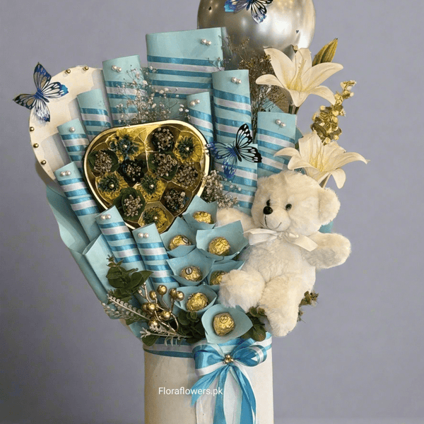 A bouquet arrangement composed of various chocolates including Snickers, Mars, KitKat, Dairy Milk, a wafer, and Ferrero Rocher, adorned with blue ribbons and decorative elements, and accompanied by a small teddy bear. Send flowers to islamabad. send flowers to pakistan