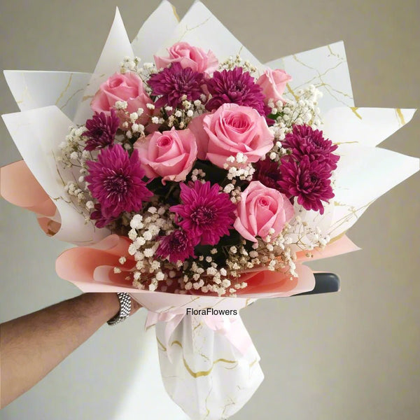 A bouquet of pink roses, purple chrysanthemums, and white baby's breath flowers with premium wrapping.
